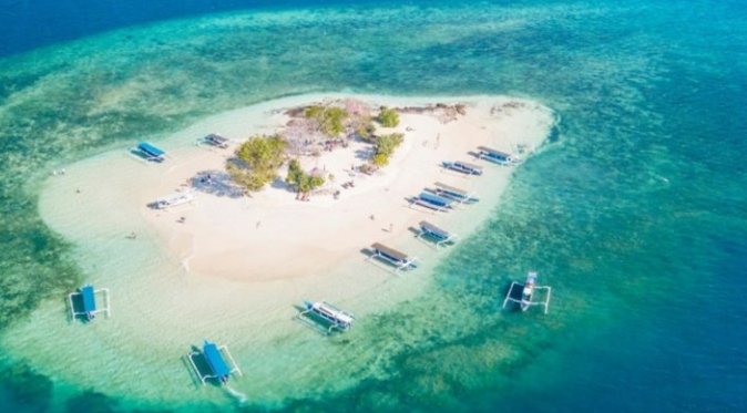 Pemandangan udara Gili Kedis, pulau pasir kecil dikelilingi kapal wisata